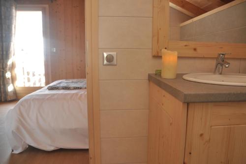 a bathroom with a bed and a sink in a room at Chalet Le Villard Samoens in Samoëns