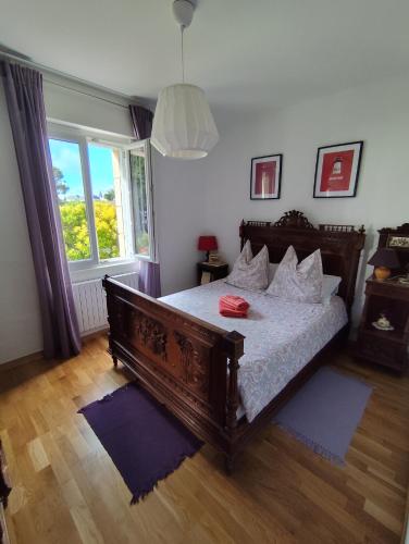 - une chambre avec un lit avec un cadre en bois et une fenêtre dans l'établissement La clé des falaises Meublé de tourisme 3 étoiles avec petite vue mer et au bord du GR 34, à Plouézec