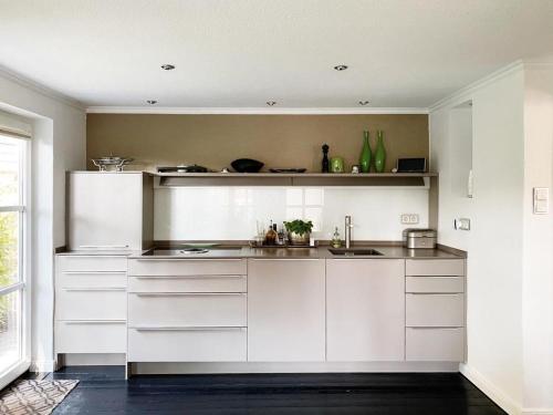 een keuken met witte kasten en een spoelbak bij Haus Cloude in Grömitz