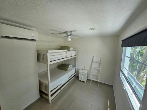 a bedroom with two bunk beds and a window at Diamante Lakes Condominium, in front of Arena GNP in Acapulco