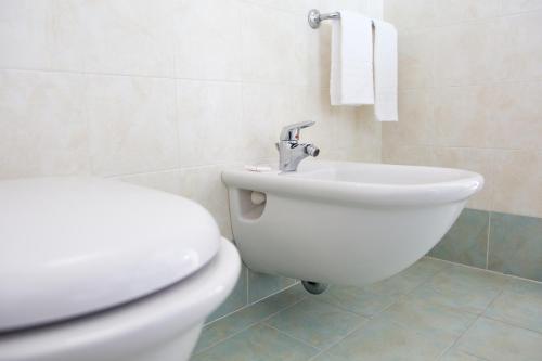 ローディ・ガルガーニコにあるAlbergo Il Giardinoの白いトイレと洗面台のあるバスルーム