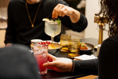 a person holding a drink on a table at Hotel Demeures de Campagne Château de Fontainebleau in Fontainebleau