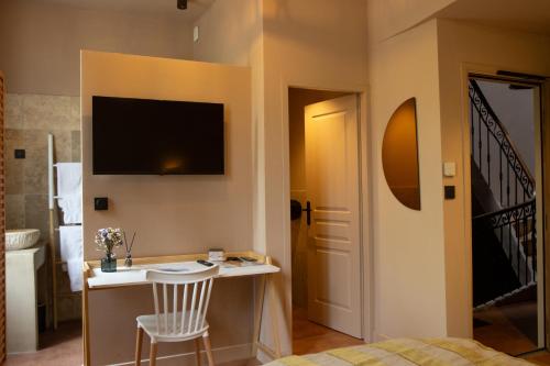 a bedroom with a bed and a desk with a chair at LE CLOS DES ARÔMES in Cassis