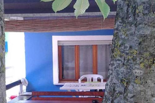 a blue house with a window and a white chair at Eureka Azienda Agrituristica in Cavallino-Treporti