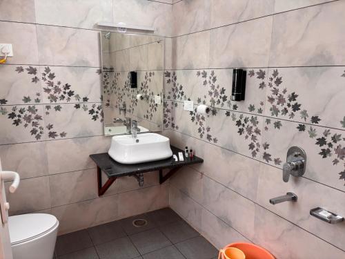 a bathroom with a sink and a toilet at Fiddlehead Fern in Dharmsala