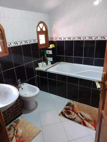 a bathroom with a tub and a toilet and a sink at 909 apartment in Amman