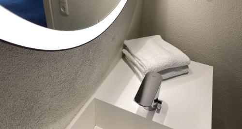 a bathroom with a sink with a mirror and towels at Hotel Dalgas, BW Signature Collection in Brande