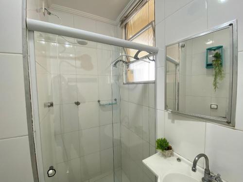 a bathroom with a shower and a sink and a mirror at Conforto perto do Mar em São Vicente! in São Vicente