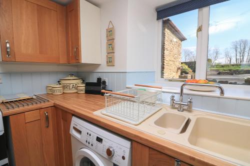 eine Küche mit Spüle und Geschirrspüler in der Unterkunft Tinkers Cottage in Kingsbridge