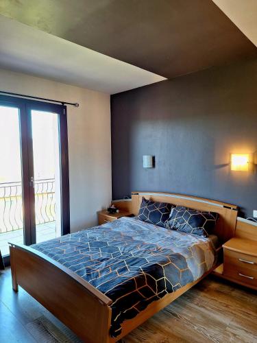 une chambre avec un grand lit et une grande fenêtre dans l'établissement Maison climatisée au calme proche des commerces, à Baume-les-Dames