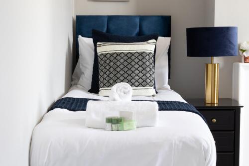 a bedroom with a white bed with a blue headboard at Chalkwell Aparthotel Short & Long Stays Welcome, Leisure , Relocation , Business Stays , Contractors in Kent