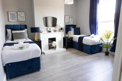 a bedroom with two beds and a fireplace at Chalkwell Aparthotel Short & Long Stays Welcome, Leisure , Relocation , Business Stays , Contractors in Kent