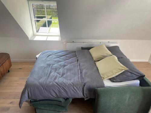 a bedroom with a bed and a couch at La maison de Nikolas in Oosterzele
