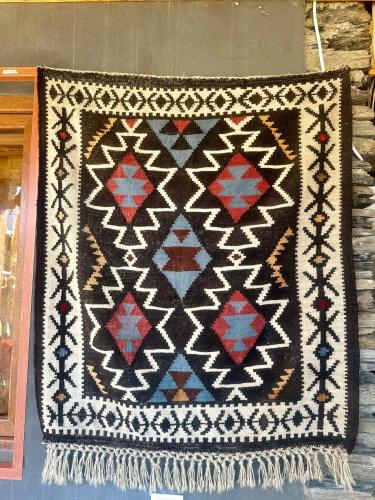 a quilt is hanging on a wall at Guesthouse Lasharai in Omalo