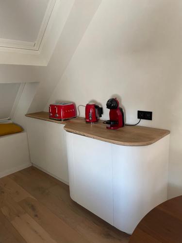 a kitchen with red appliances on top of a counter at La maison de Nikolas in Oosterzele
