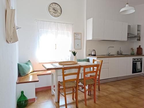 a kitchen with a table and chairs in a room at Su 'e Torigheddu - Casa con terrazza panoramica in Cuglieri