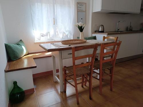 a kitchen with a table with chairs and a counter top at Su 'e Torigheddu - Casa con terrazza panoramica in Cuglieri