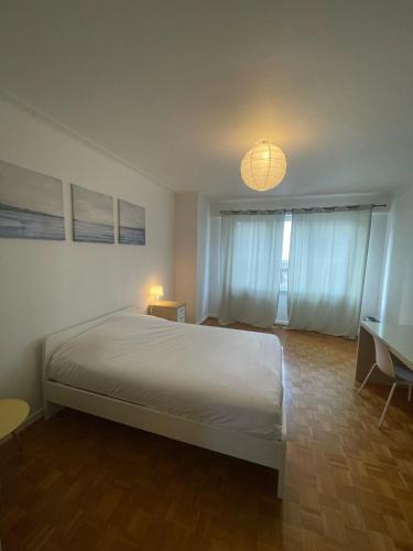 une chambre avec un lit et une lumière au plafond dans l'établissement Large Apartment Free Parking Mulhouse, à Mulhouse