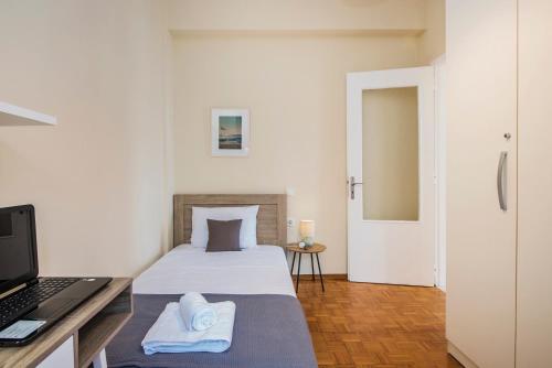 um quarto com uma cama e uma escrivaninha com um laptop em Aurum Syros em Hermópolis