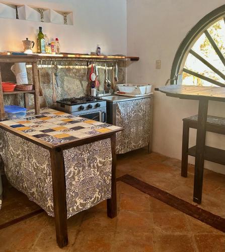 a kitchen with a table and a stove in it at Lo Cósmico in Zipolite