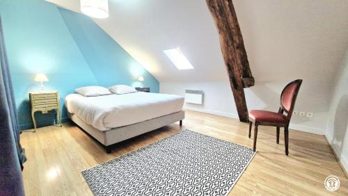 une chambre avec un lit et une chaise dans l'établissement La Sauveroise, à Saint-Sauveur-en-Puisaye