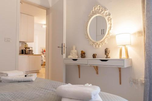 a white bedroom with a mirror and a bed at Arline's Luxury Retreat House in Sarandë
