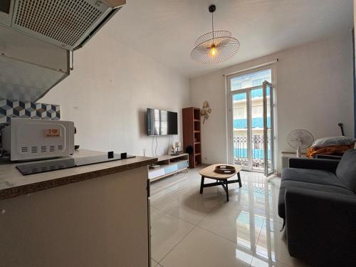 une cuisine et un salon avec un canapé et une table dans l'établissement Studio 1 Libération Nice proche tramway, à Nice