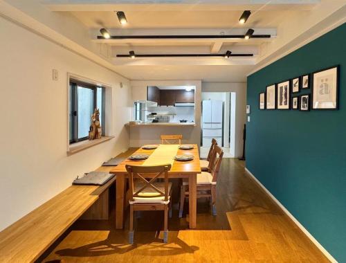 a dining room with a large wooden table and chairs at 渋谷高級一戸建て 貸切 テラス付き 最大七名 in Tokyo