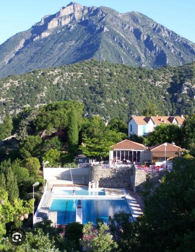 une maison avec une piscine en face d'une montagne dans l'établissement Spacieux 2 pièces à 30mn de Nice, à Levens