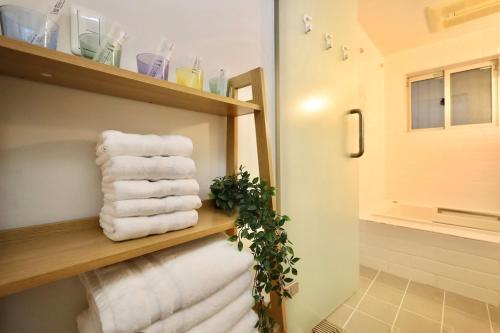 a bathroom with white towels on a wooden shelf at 渋谷高級一戸建て 貸切 テラス付き 最大七名 in Tokyo