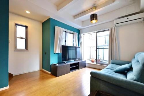 a living room with a couch and a flat screen tv at 渋谷高級一戸建て 貸切 テラス付き 最大七名 in Tokyo