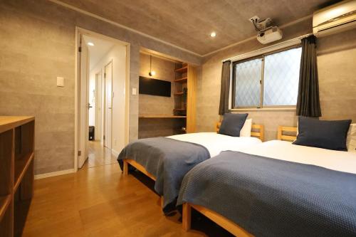 a hotel room with two beds and a window at 渋谷高級一戸建て 貸切 テラス付き 最大七名 in Tokyo