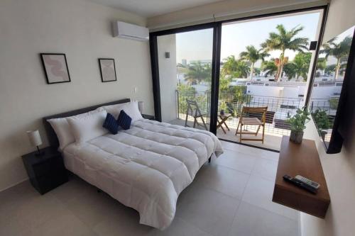 a large white bed in a room with a large window at Oasis de Montebello by Kanaa in Mérida