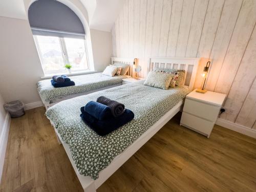 a bedroom with two beds with towels on them at Luxury Penthouse Apartment overlooking Main Beach in Bundoran