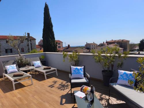 a patio with chairs and tables on a balcony at Rooms and Apartments IstraSoley in Bale