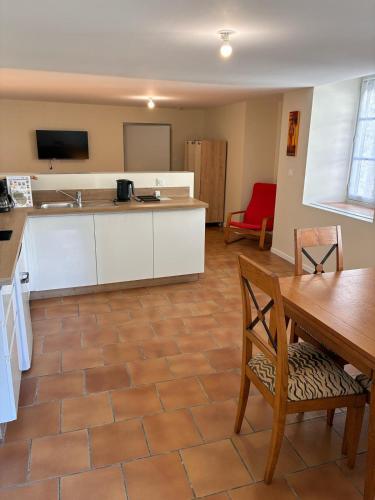 a kitchen with a table and a dining room at Charmant studio centre d Ecueille in Écueillé