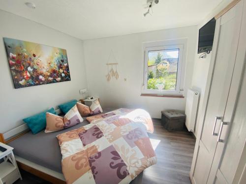 マイニンゲンにあるFerienhaus Kastanienalleeのベッドと壁に絵が飾られた寝室