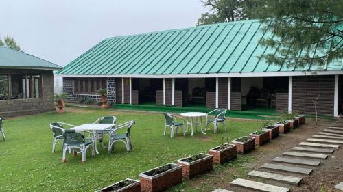 a group of tables and chairs in front of a house at Green Manal Hotel in Abbottābād