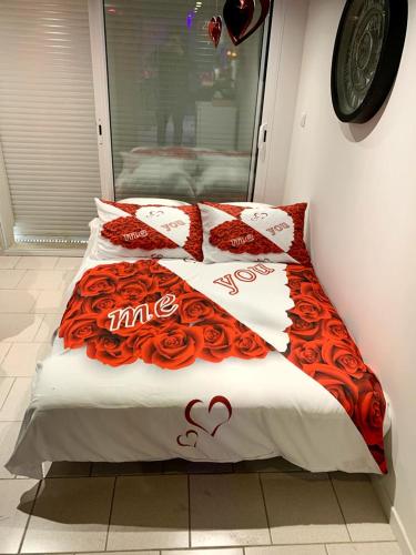 - un lit avec des oreillers rouges et blancs et un micro-ondes dans l'établissement le cocon de gepetto spa privatif, à Fussy