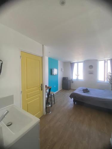 a bedroom with a bed and a yellow door at Capstay Point central ch3 - Netflix in Tourcoing