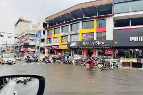 Eine Stadtstraße mit einer Ansammlung von Motorrädern, die vor einem Gebäude geparkt sind. in der Unterkunft OYO The 3 Star Hotel in Jabalpur