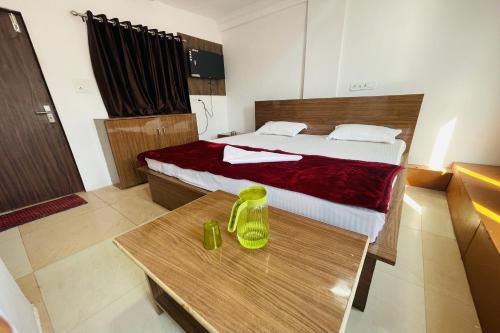 ein Schlafzimmer mit einem Bett und einem Tisch, auf dem ein gelber Gegenstand steht in der Unterkunft OYO The 3 Star Hotel in Jabalpur