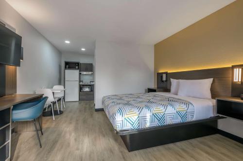 a hotel room with a bed and a kitchen at Studio 6 Columbus GA Columbus Airport in Columbus