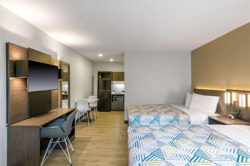 a hotel room with two beds and a desk at Studio 6 Columbus GA Columbus Airport in Columbus