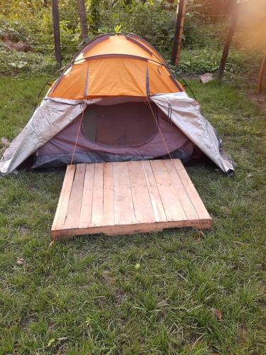a tent sitting on the grass with a wooden floor at Refugio Los Naranjales in El Colegio