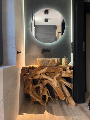 a bathroom with a wooden table with a sink and a mirror at W szczerym lesie - Domek z sauną i jacuzzi w lesie nad Jeziorem Mucharskim in Dąbrówka