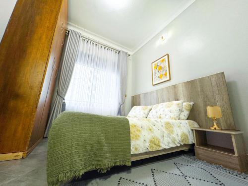 a bedroom with a bed and a window at Tanzi Homes 1 Manzi in Mbarara