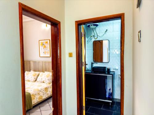 a bedroom with a bed and a mirror in a room at Tanzi Homes 1 Manzi in Mbarara