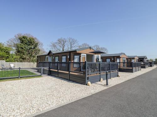 a modular home with a fence and gravel at Casa De Rhu in Evesham