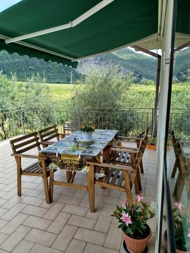a table and chairs on a patio with a green canopy at L'oasi di Alice in Sermoneta